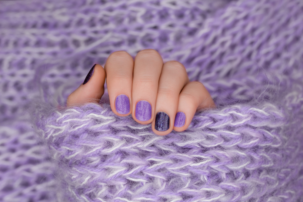 purple-nail-design-manicured-female-hand-purple-background